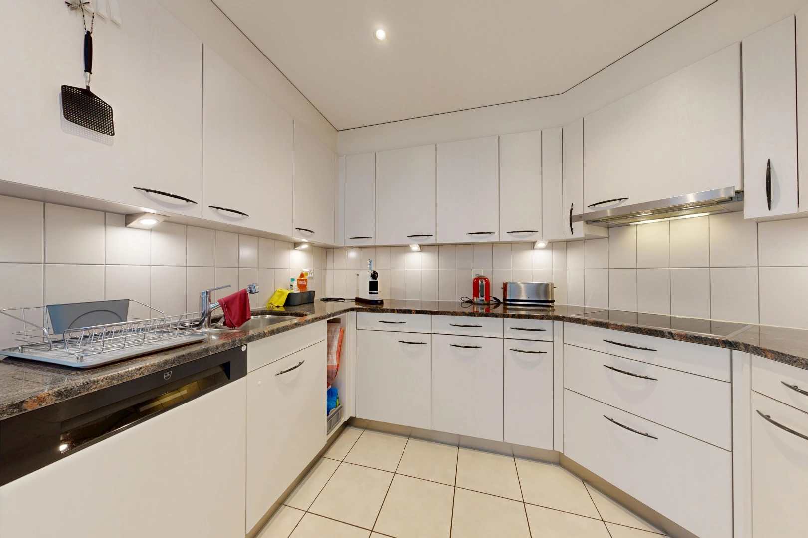 kitchen with white cabinetry, dark stone counters, light tile patterned floors, and tasteful backsplash