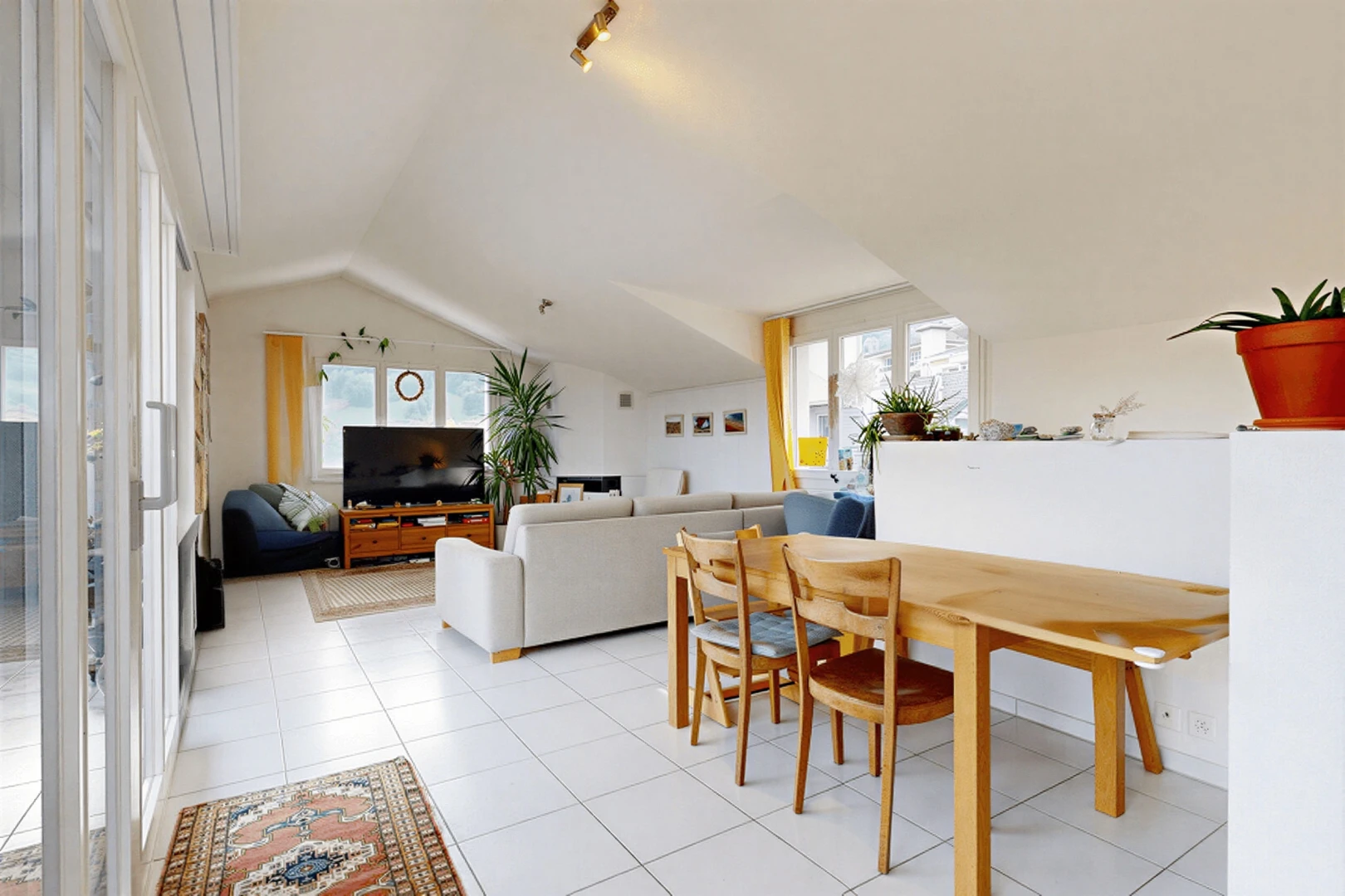 living room featuring lofted ceiling, healthy amount of natural light, and light tile patterned floors