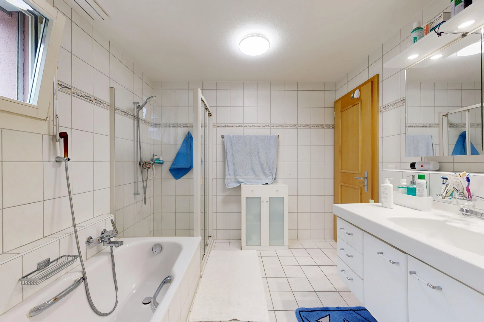 bathroom featuring tile walls, a bath, vanity, a stall shower, and light tile patterned floors