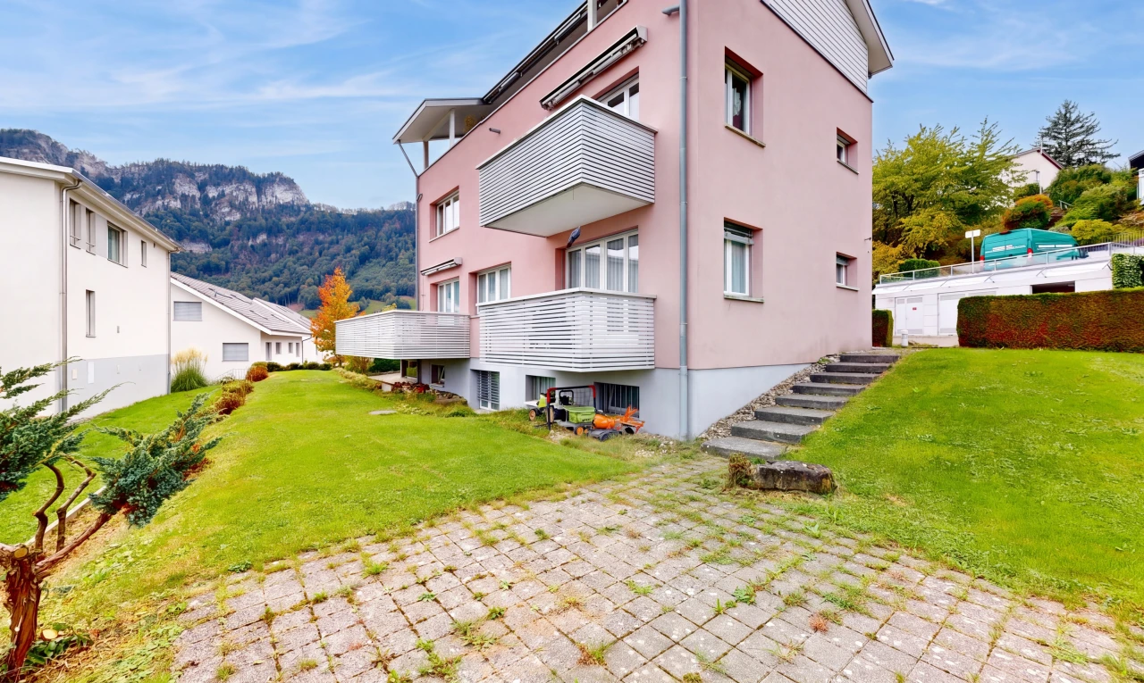 outdoor house with a lawn, stucco siding, and a mountain view