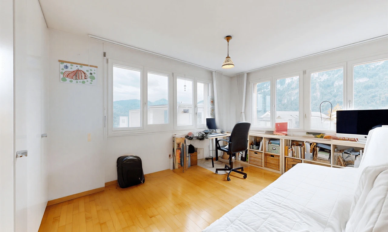 room / bedroom featuring an office area, pendant lighting, and light wood-style floors