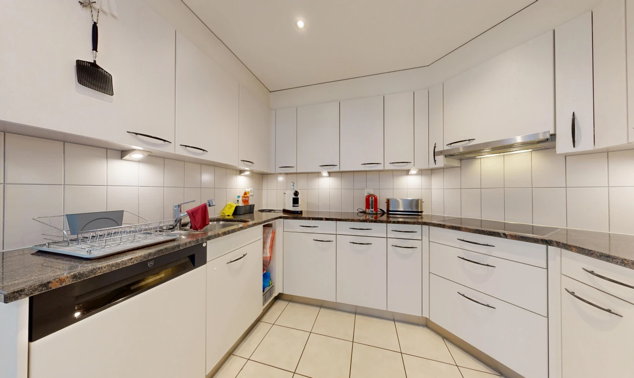 kitchen with white cabinetry, dark stone counters, light tile patterned floors, and tasteful backsplash