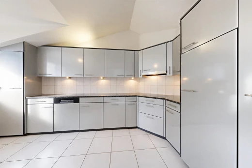 kitchen featuring vaulted ceiling, light tile patterned floors, tasteful backsplash, and gray cabinets