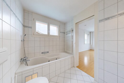 full bathroom featuring radiator, light tile patterned floors, and tile walls