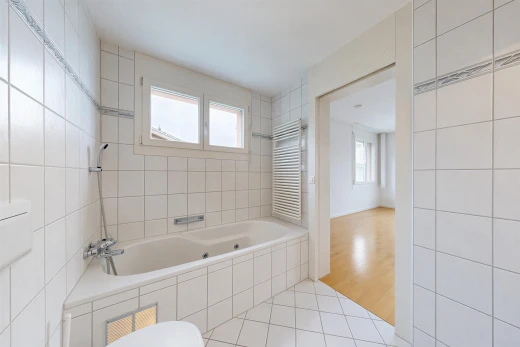 full bathroom featuring radiator, light tile patterned floors, and tile walls