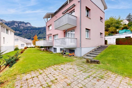 outdoor house with a lawn, stucco siding, and a mountain view