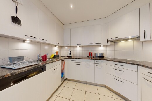 kitchen with white cabinetry, dark stone counters, light tile patterned floors, and tasteful backsplash