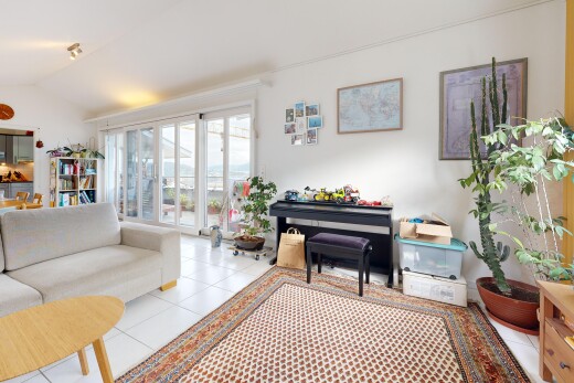 living room with lofted ceiling, access to exterior, and light tile patterned floors