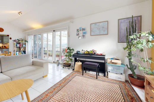 living room with lofted ceiling, access to exterior, and light tile patterned floors