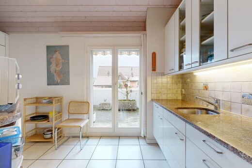 cuisine avec armoires blanches, white cabinets, plans de travail en pierre, stone countertops, et lumière naturelle