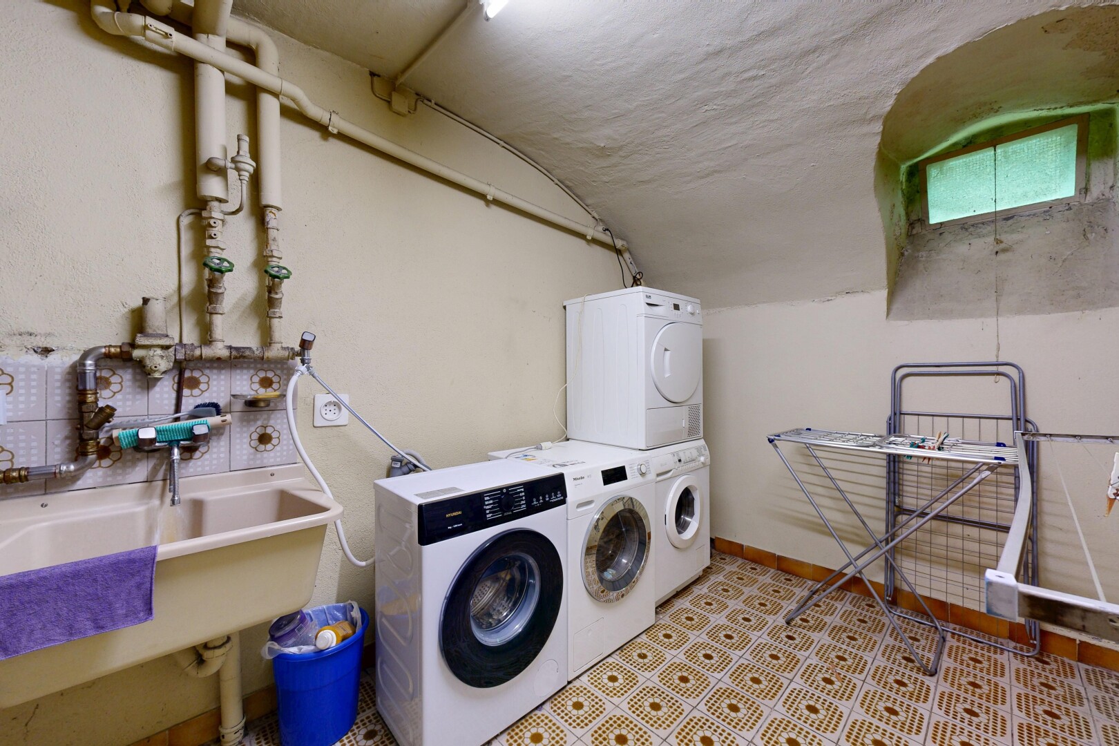 buanderie avec évier, inside property, lave-linge et sèche-linge superposés, drywall, et cloison sèche