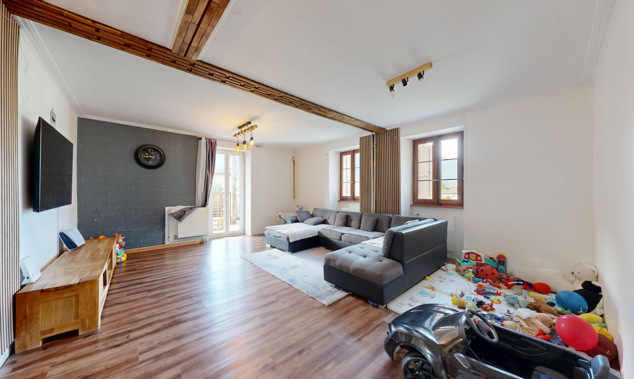 salon avec drywall, cloison sèche, wood finish floor, sol en finition bois, et télévision