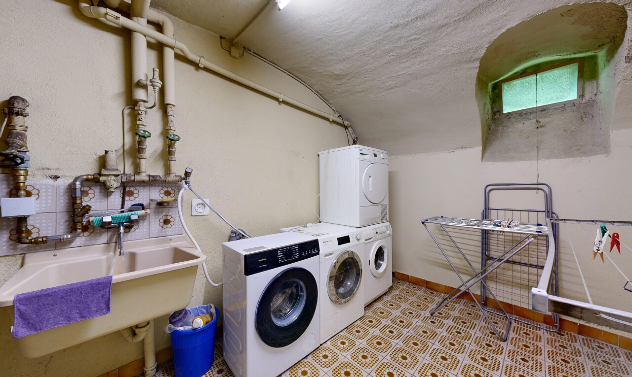 buanderie avec évier, inside property, lave-linge et sèche-linge superposés, drywall, et cloison sèche