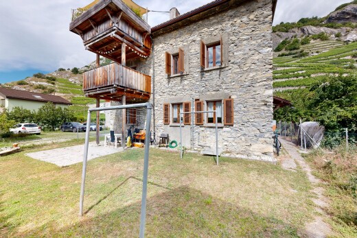 façade avec terrasse, bardage en pierre, pelouse, et property visible