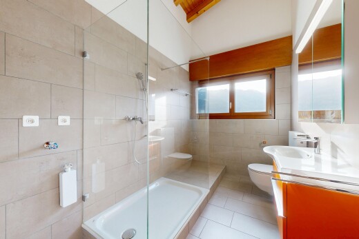 bathroom featuring tile walls, a shower stall, vanity, and light tile patterned floors