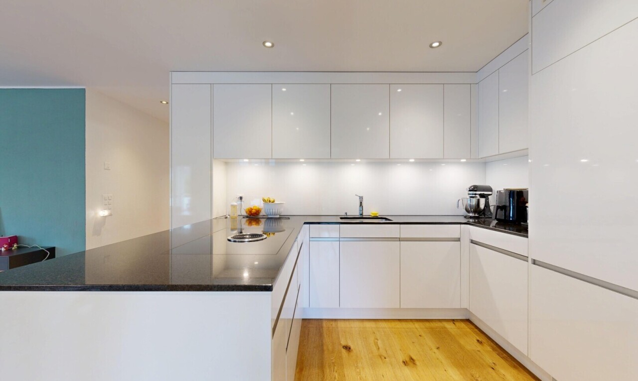 küche mit dark countertops, flat panel cabinets, schränke mit flachen paneelen, wood finish floor, und holzfußboden