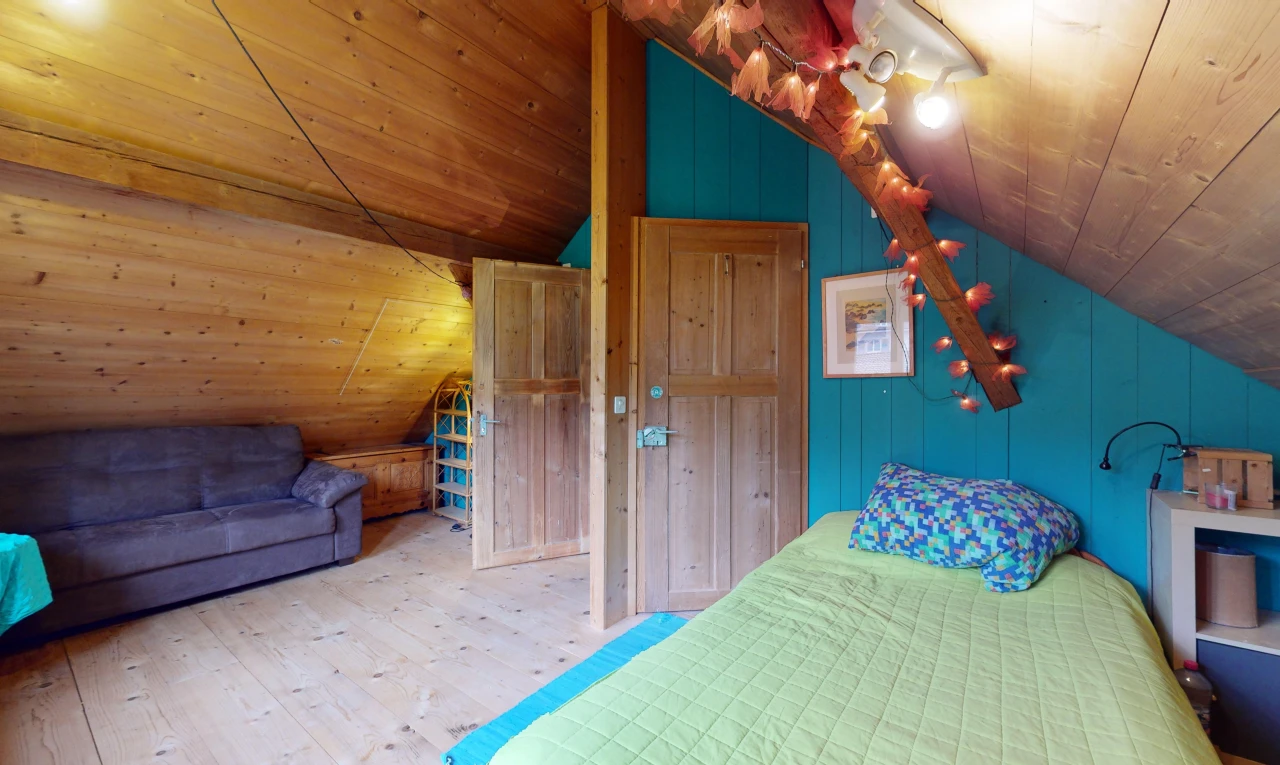 chambre avec plancher de bois, plafond voûté, plafond de bois, et mur en bois