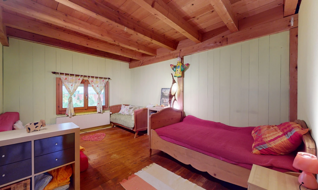 chambre avec plancher de bois, plafond de bois, poutres apparentes, lumière naturelle, et radiateur