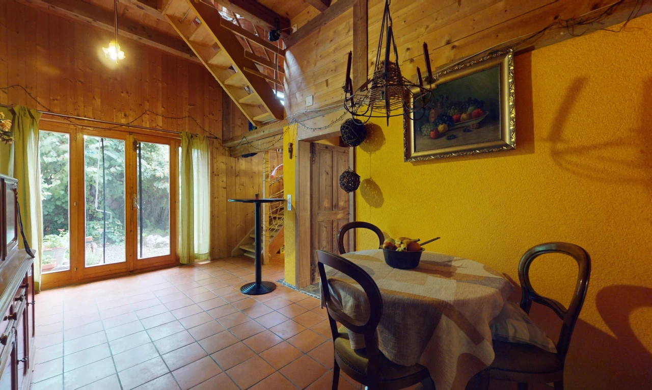 salle à manger avec carrelage, poutres apparentes, lumière naturelle, et mur en bois