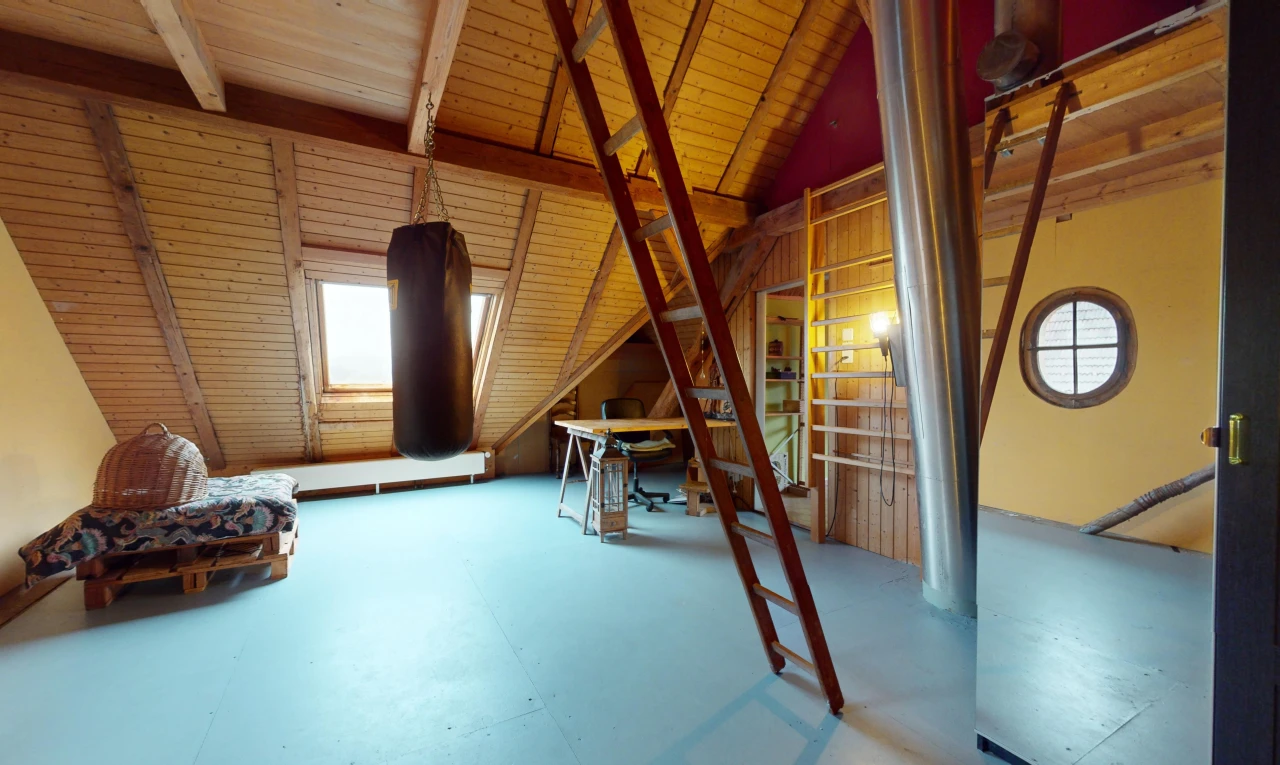 chambre avec poutres apparentes, plafond de bois, plafond voûté, sol en béton, et lumière naturelle