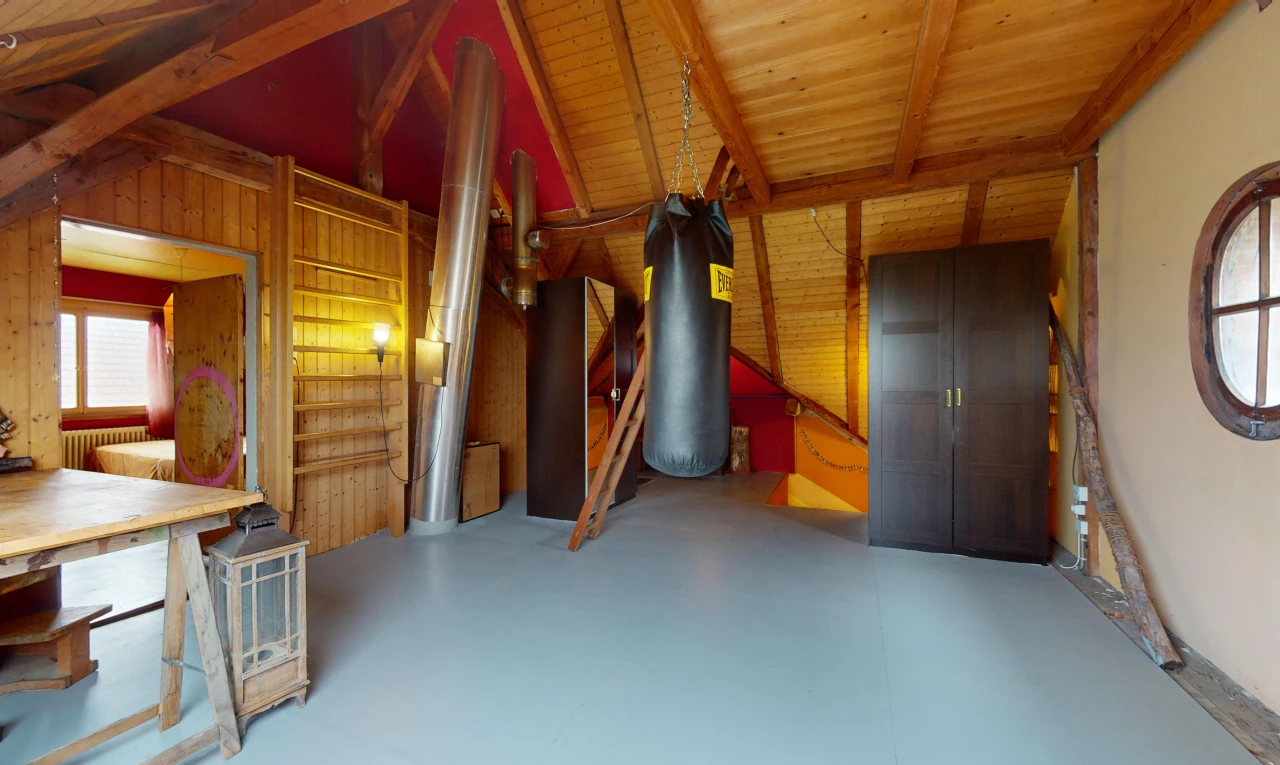 chambre avec poutres apparentes, plafond de bois, plafond voûté, sol en béton, et lumière naturelle
