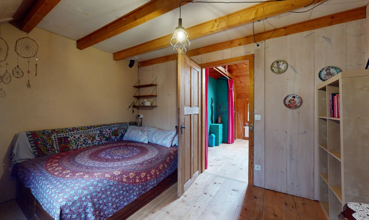 chambre avec poutres apparentes, plancher de bois, et mur en bois