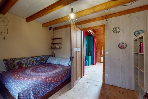 room / bedroom featuring beamed ceiling, wooden walls, and light hardwood / wood-style floors
