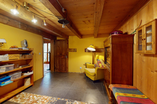 espace intérieur avec plafond de bois, poutres apparentes, mur en bois, lumière naturelle, et éclairage sur rail