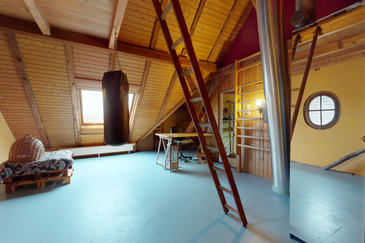 chambre avec poutres apparentes, plafond de bois, plafond voûté, sol en béton, et lumière naturelle