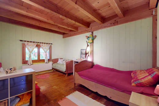chambre avec plancher de bois, plafond de bois, poutres apparentes, lumière naturelle, et radiateur