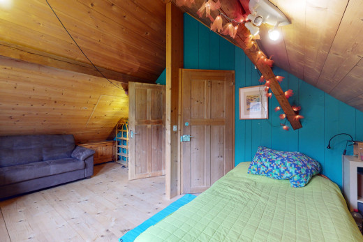 chambre avec plancher de bois, plafond voûté, plafond de bois, et mur en bois