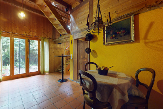salle à manger avec carrelage, poutres apparentes, lumière naturelle, et mur en bois