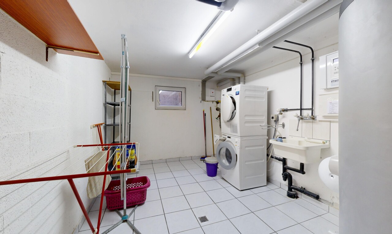 buanderie avec light floor, lave-linge et sèche-linge superposés, inside property, évier, et sol en carrelage