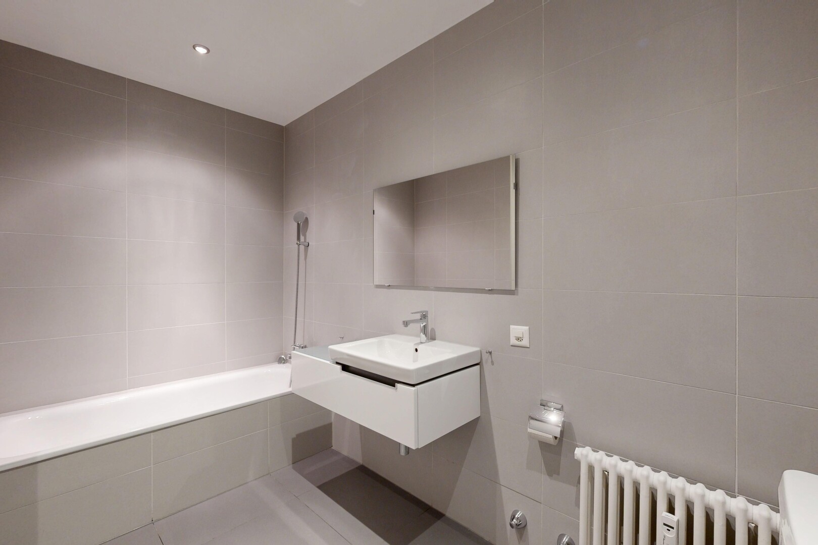 bathroom with tile walls, a relaxing tiled tub, vanity, recessed lighting, and radiator heating unit