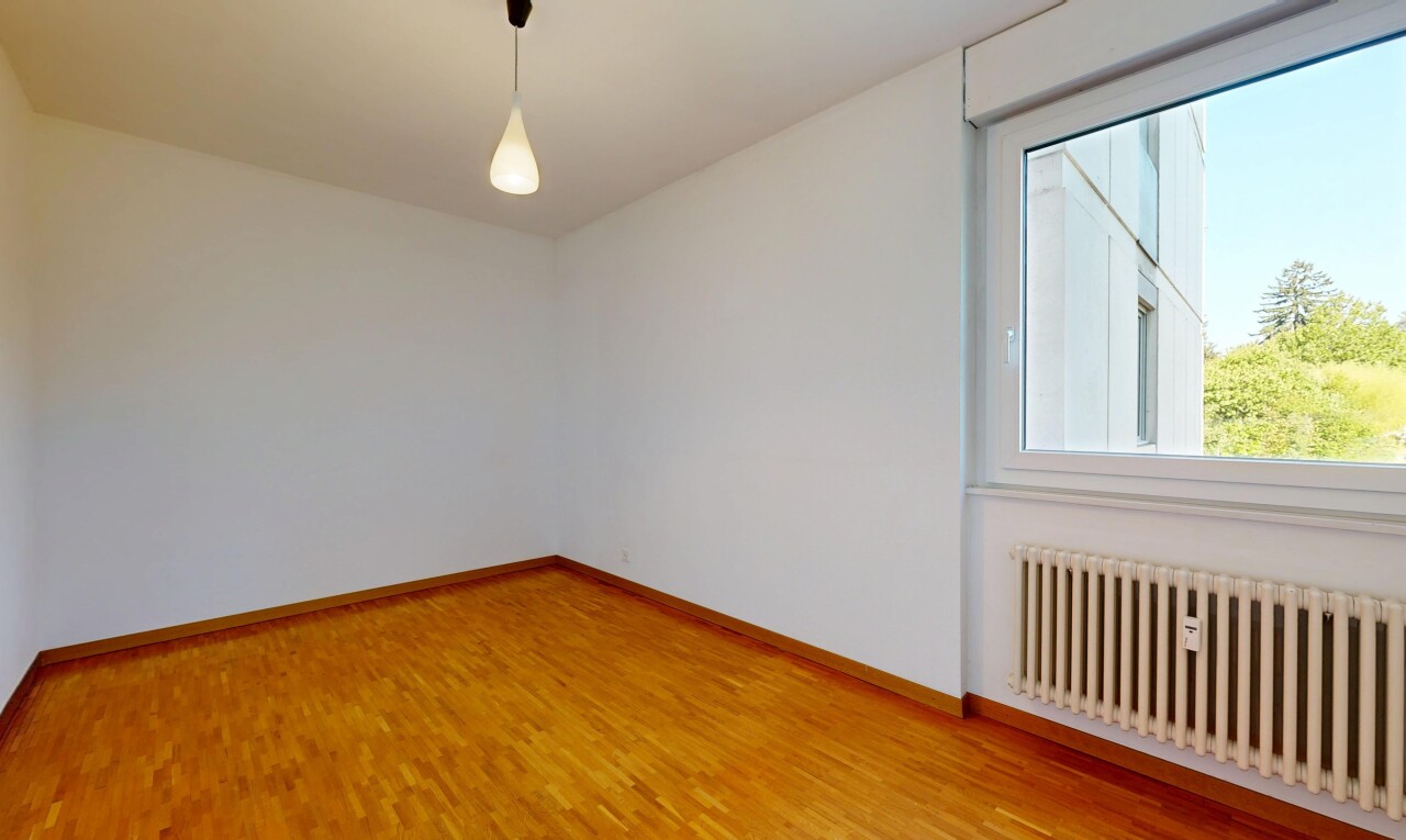 empty room with radiator, decorative light fixtures, and light wood-type flooring