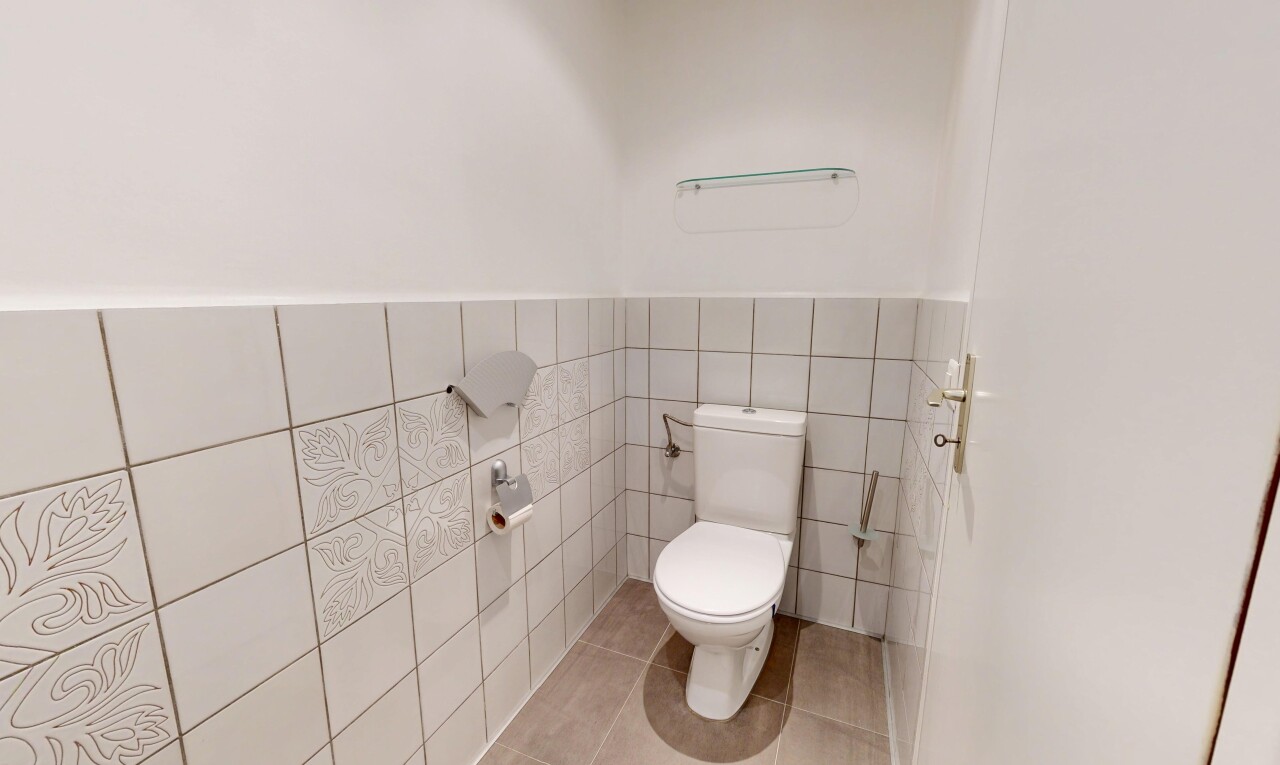 bathroom featuring tile walls, light tile patterned flooring, and a wainscoted wall