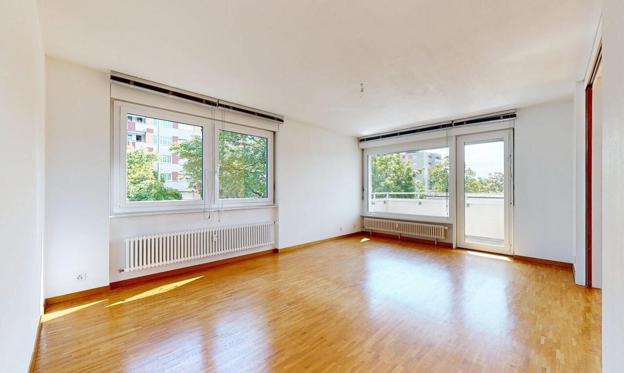 unfurnished room with radiator heating unit, light wood-style floors, and healthy amount of natural light