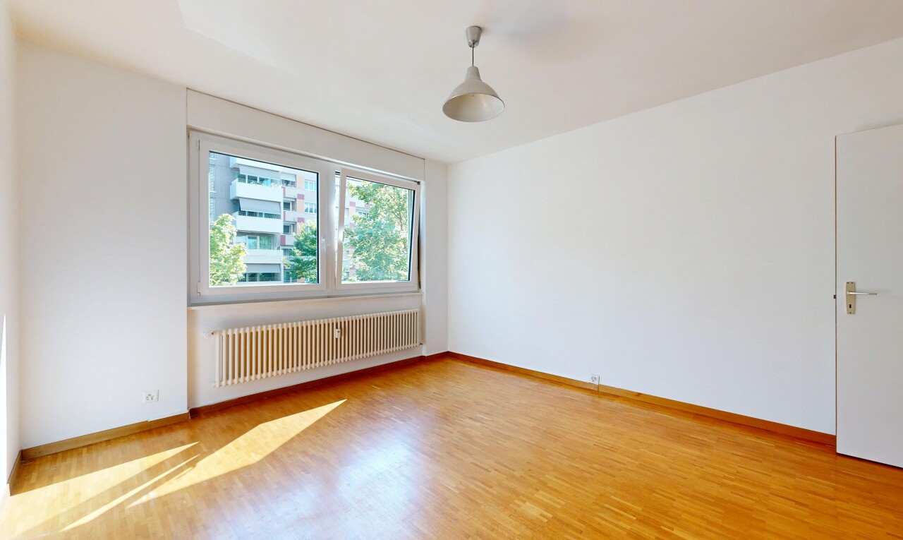 spare room with radiator, decorative light fixtures, and light wood-style floors