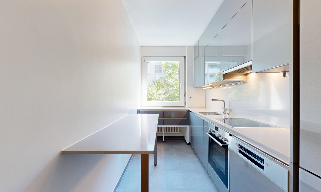 two tone kitchen featuring stainless steel appliances, modern cabinets, light countertops, and two tone color scheme