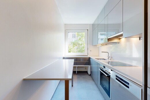 two tone kitchen featuring stainless steel appliances, modern cabinets, light countertops, and two tone color scheme