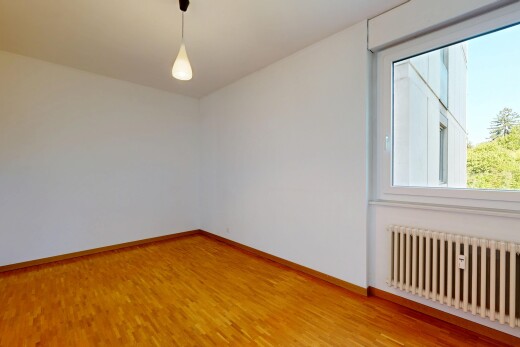 empty room with radiator, decorative light fixtures, and light wood-type flooring