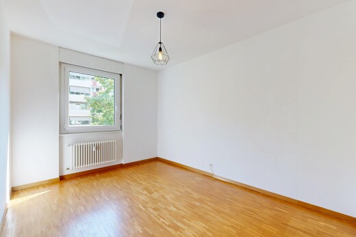 spare room featuring radiator heating unit, light wood-style flooring, and hanging light fixtures