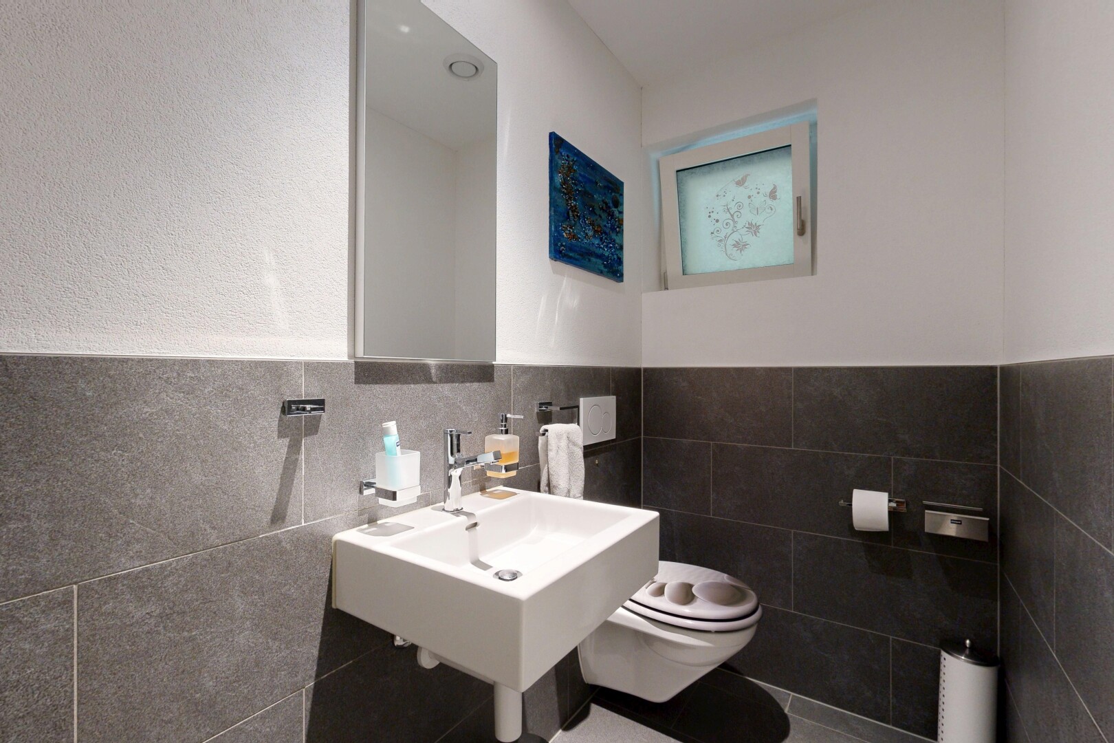 salle de bains avec toilette, inside property, miroir, mur à lambris, et wainscot wall