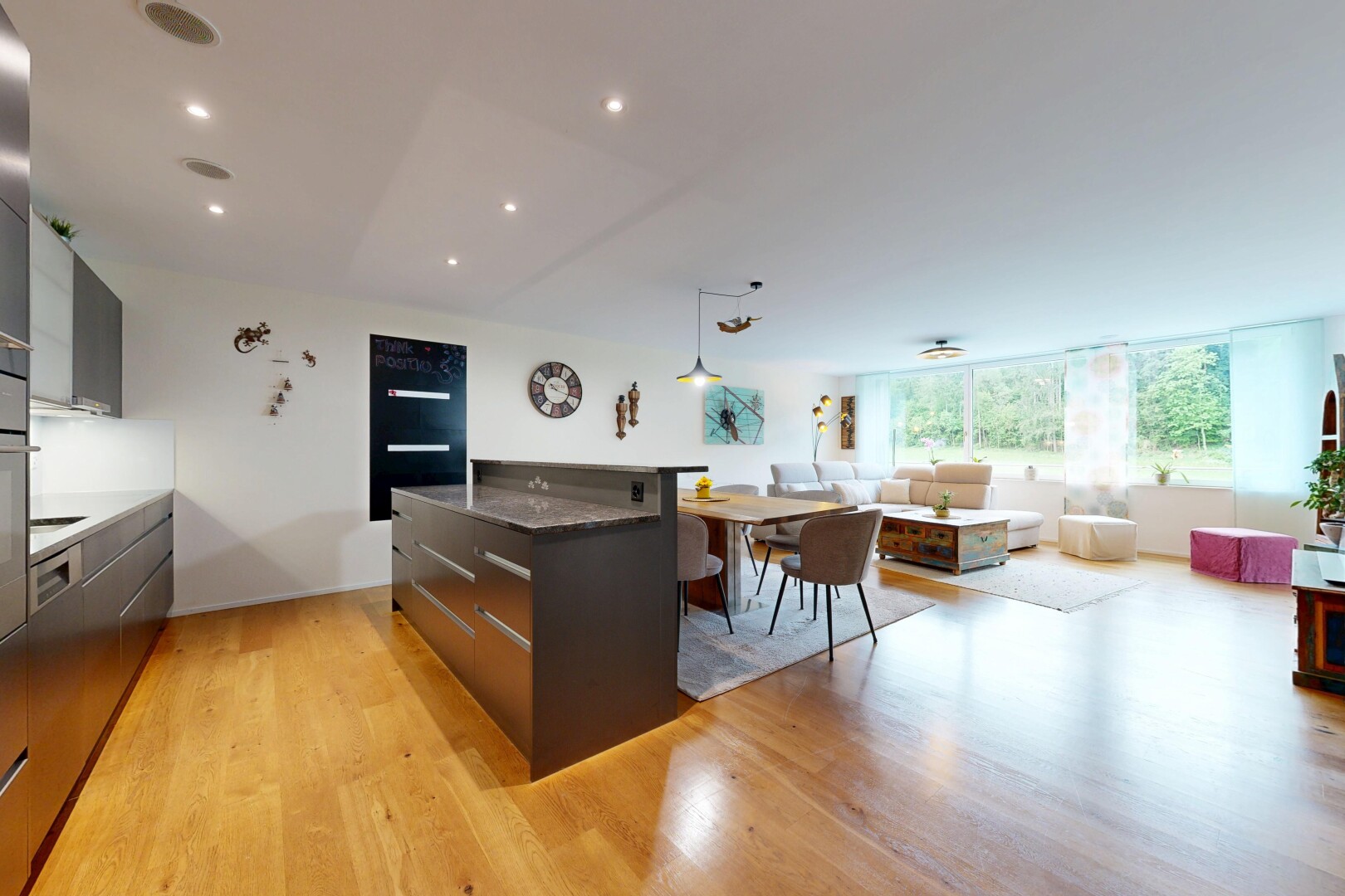 cuisine avec two heights countertops, armoires à panneau plat, flat panel cabinets, light floor, et dark countertops