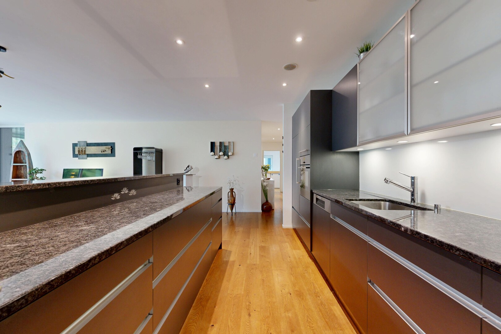 cuisine avec dark countertops, stone countertops, plans de travail en pierre, flat panel cabinets, et armoires à panneau plat