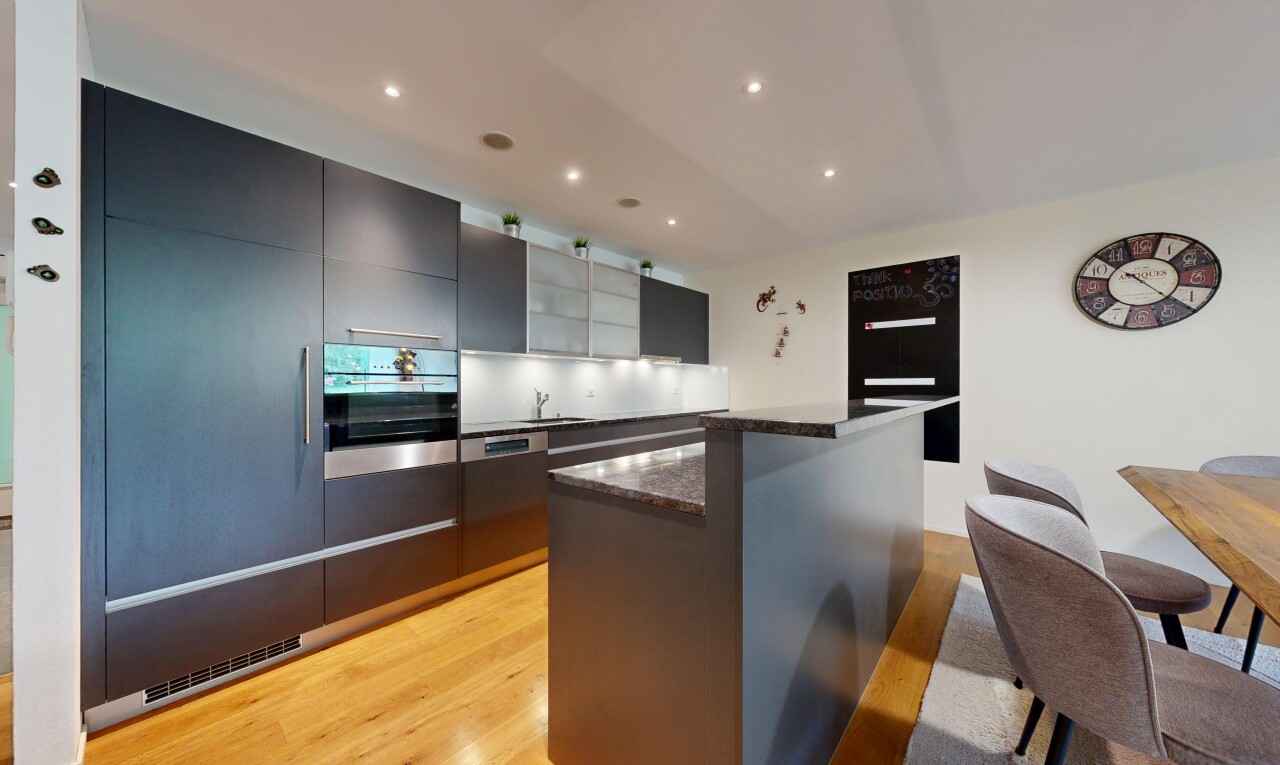 cuisine avec two heights countertops, dark countertops, light floor, îlot de cuisine, et kitchen island
