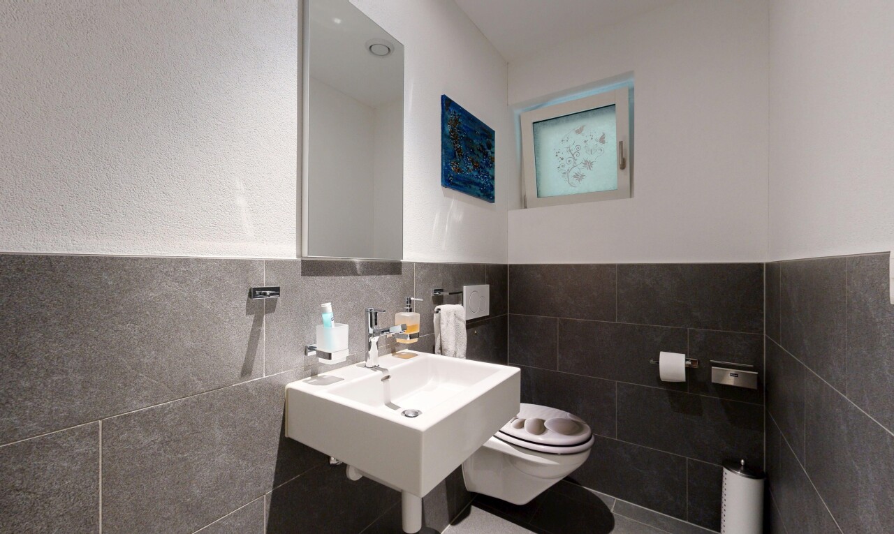 salle de bains avec toilette, inside property, miroir, mur à lambris, et wainscot wall
