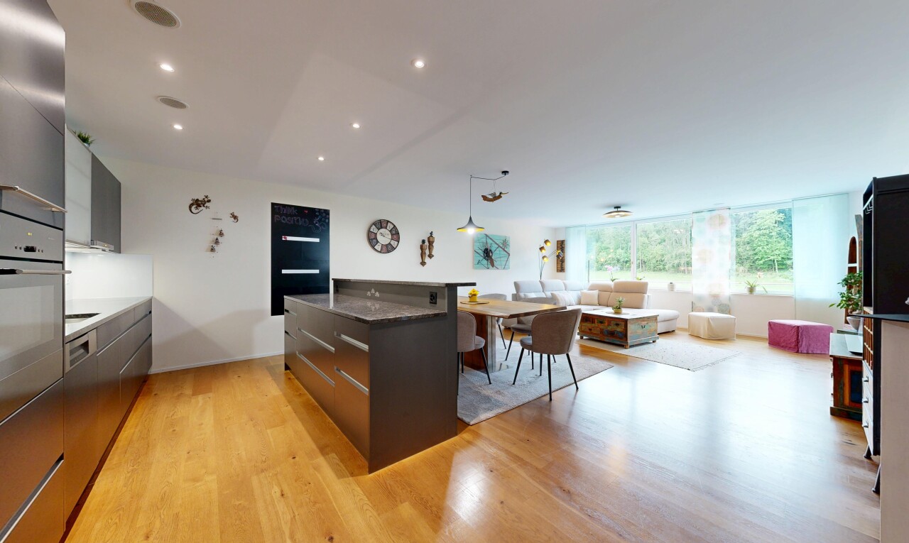 cuisine avec two heights countertops, armoires à panneau plat, flat panel cabinets, light floor, et dark countertops