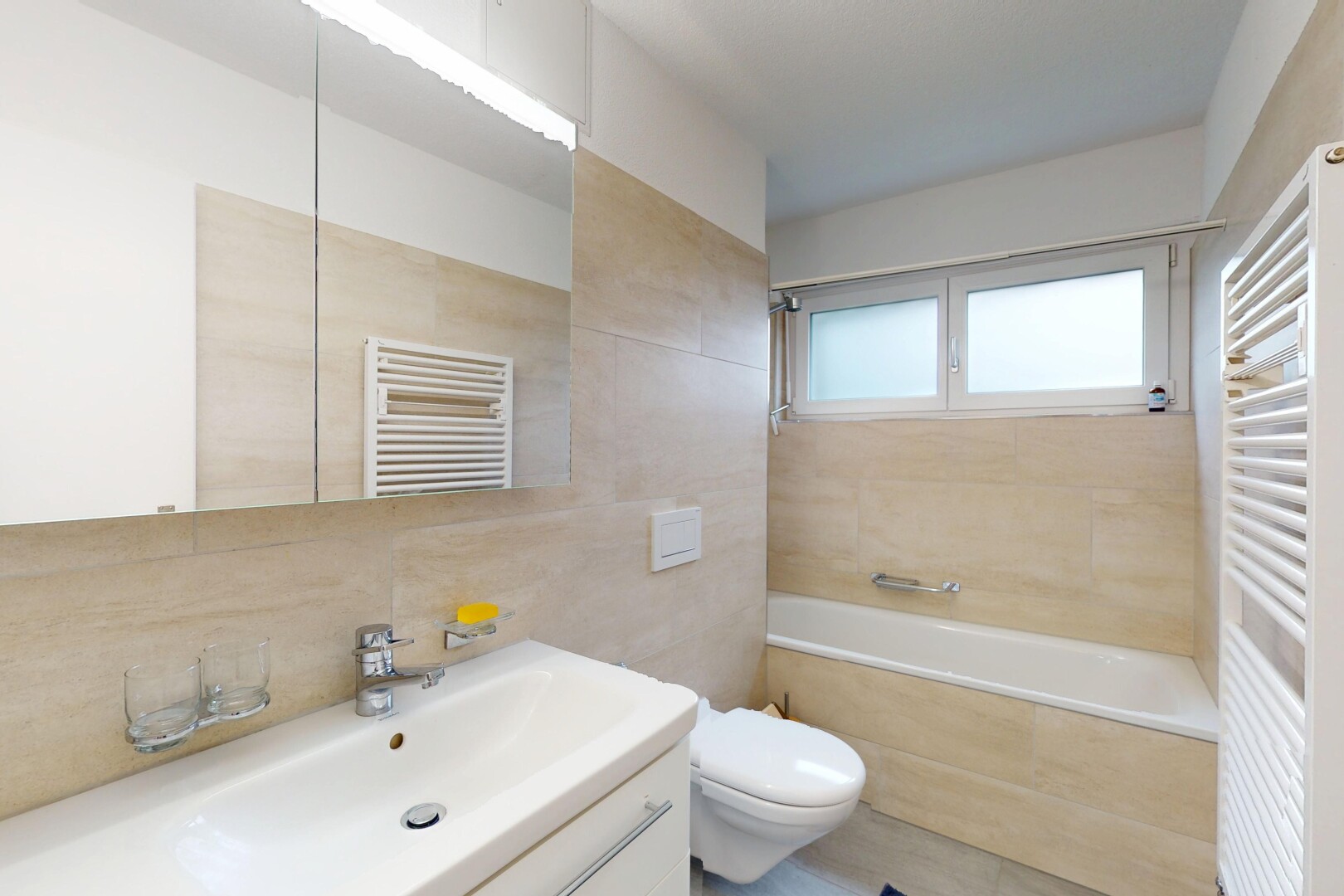 bathroom with radiator, a towel warming rack, vanity, and tile walls