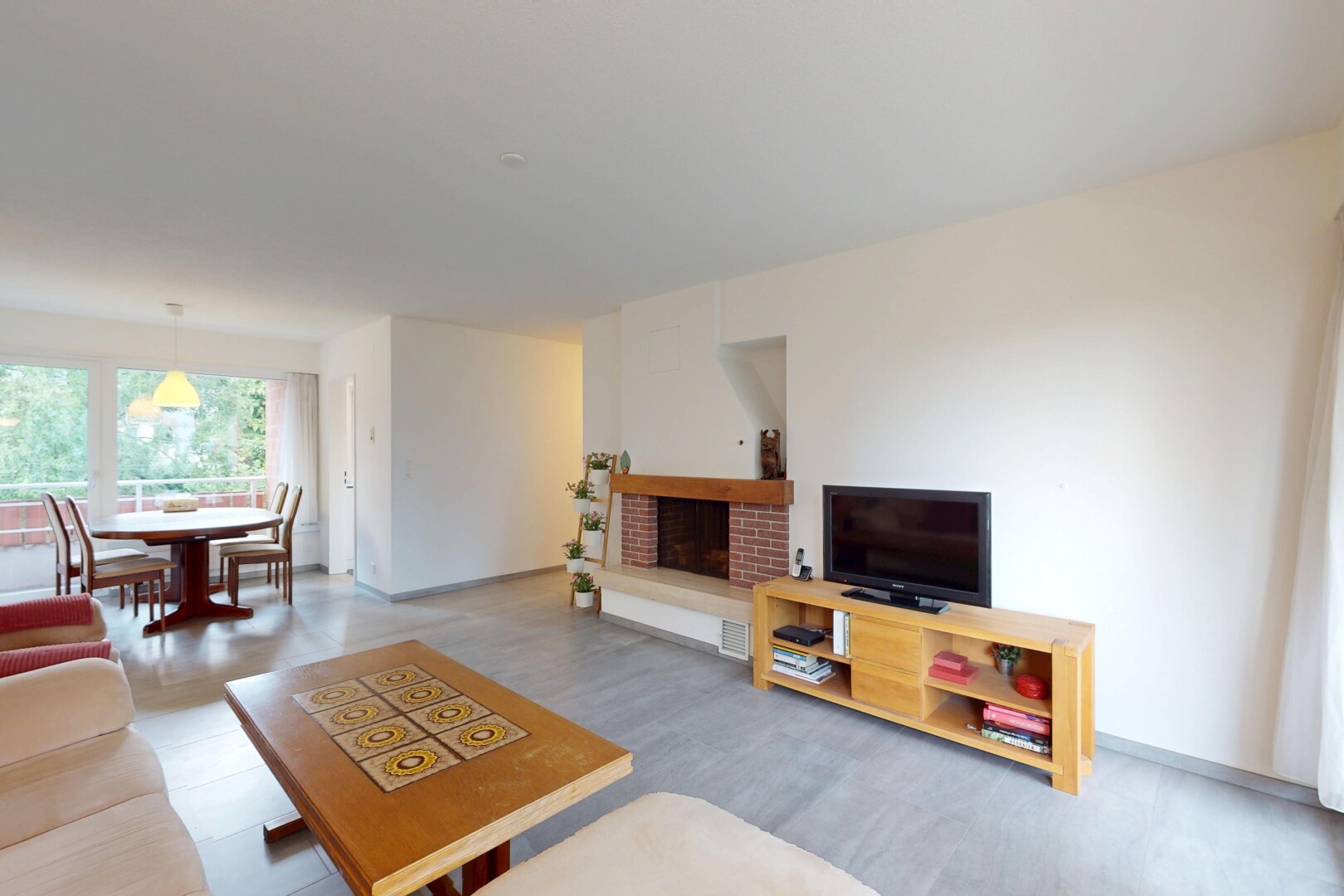 living / dining area featuring a brick fireplace and wood finished floors